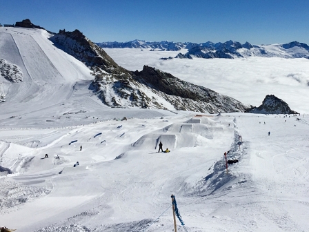 Zwei Snowboarder vor einer Linie aus Schanzen