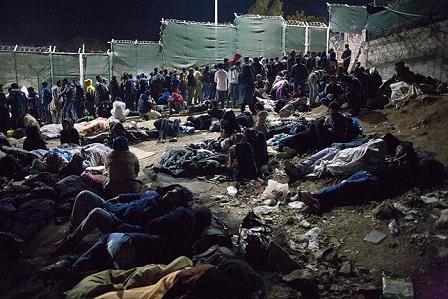 Schlange vor der Registrierung Nachts in Moria. Daneben auf einem Feld schlafen Frauen und Kinder auf Plastikplanen.