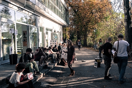 BesucherInnen des Elevate Festivals sitzen und stehen vor dem Forum Stadtpark in Graz