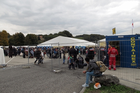 Ein Refugee sitzt auf einem Stein und schaut auf den Platz, wo die Polizei eine Registrierungsstelle eingerichtet hat. Nahe dem Grenzübergang Spielfeld