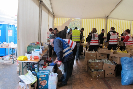 Freiwillige HelferInnen teilen Bananen, Weißbrot, Tee und Wasser an Flüchtlinge aus im Zelt des Roten Kreuzes in Spielfeld