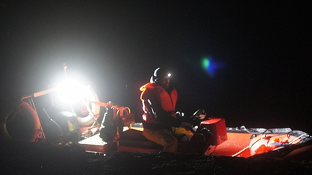 Mann bei Nacht in einem Schlauchboot