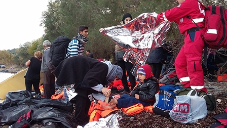 Flüchtlinge am Strand wickeln sich in Alu Decken