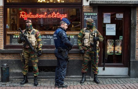 A Police officer and soldiers stand guard  in the 'Rue des Bouchers' street, famous for it's restaurants, in Brussels, Belgium, 22 November 2015.