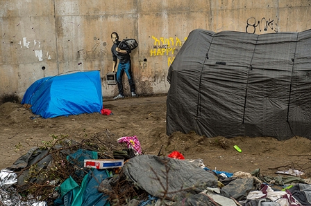 Zelte vor einem Banksy-Portrait von Steve Jobs