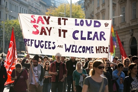 Menschen mit Refugees Welcome Banner