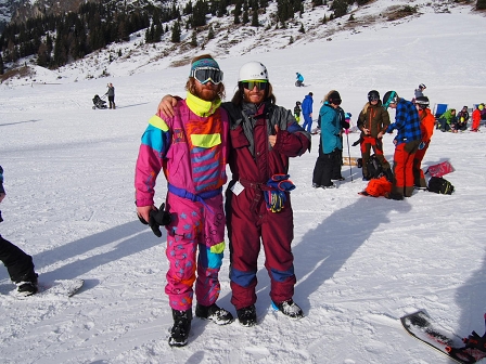 Zwei Snowboarder in grellen Ganzkörperoveralls