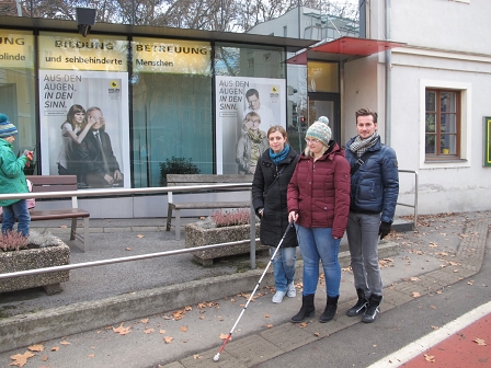 Melanie Zraunig mit KollegInnen geht entlang eines Leitsystems am Gehsteig vor dem Grazer Odilieninstitut