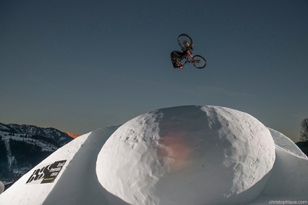 Mountainbiker springt über eine Schneeschanze