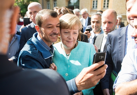 Angela Merkel macht ein Selfie mit einem Flüchtling