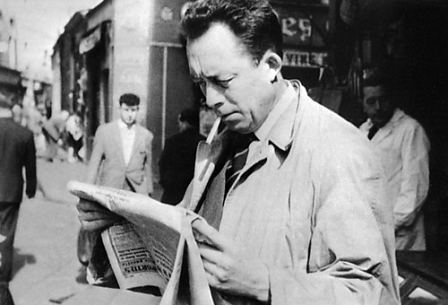 Albert Camus mit einer Zeitung