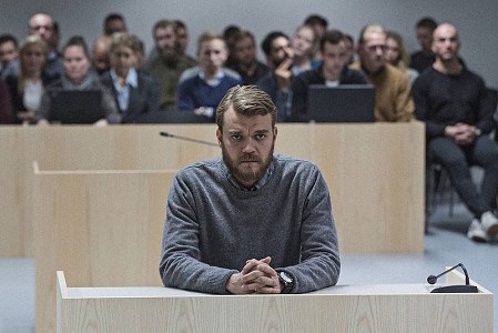 Johan Philip Asbæk sitzt auf der Anklagebank in einem Gerichtssaal, Filmstill aus "A War" 