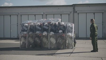 PolizistInnen haben sich mit Schutzschildern zu einer Formation zusammengestellt, daneben steht eine ausbildende Polizistin. Filmstill aus "Staatsdiener"