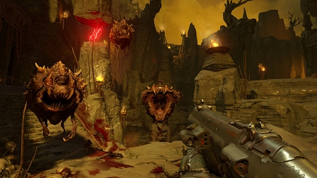 Screenshot aus "Doom": Höllenkreaturen und eine Waffe im Anschlag.