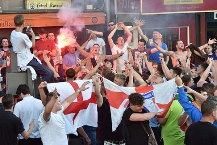 England supporters wave flags and light a flare in central Lille on June 15, 2016, on the sideline of the Euro 2016 football championship