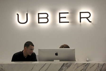 UBER-Logo und zwei Mitarbeiter