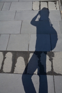 Schatten einer Reisenden mit Rucksack und Kamera