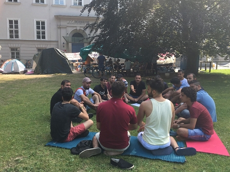 Männer aus dem Irak, Syrien und Afghanistan sitzen im Grazer Stadtpark und beraten über die Verlängerung ihres Refugees Protest Camps.