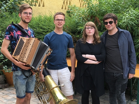 Johannes Kölbl, Tobias Weiß, Natalie Ofenböck und Der Nino aus Wien stehen im Hof eines Heurigen 