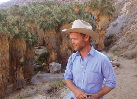 Christian Kracht mit Cowboyhut in einer Landschaft mit Palmen