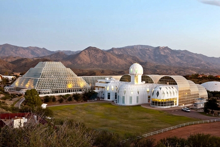 Das Biosphere-2-Gelände in Oracle, Arizona. Eine Glaspyramide und ein Kontrollzentrum vor einer Berglandschaft