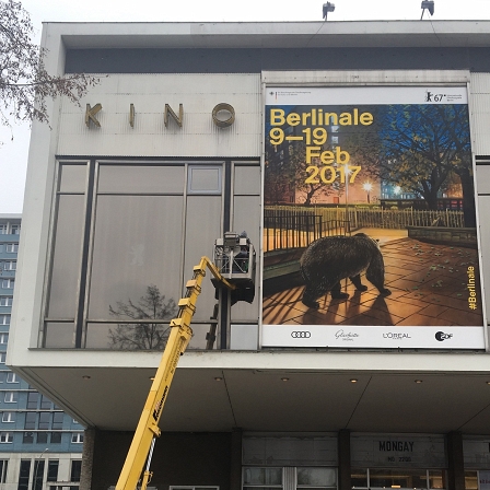 Ein Fensterputzer auf einem Kran an der Fassade des Kino International in Berlin