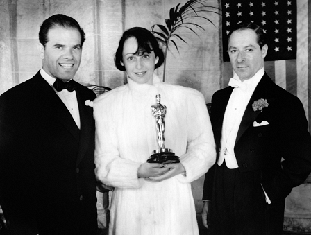 Best actress Luise Rainer surrounded by US director Frank Capra and the host George Jessel holds her trophy during the 9th Academy Awards on March 4