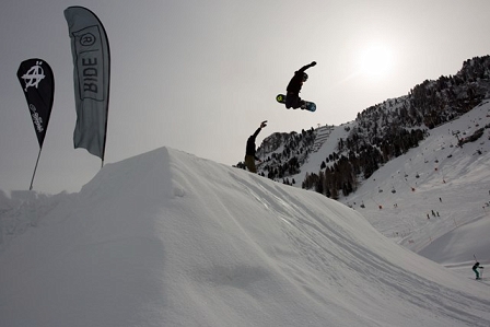 Snowboarder springt über Schanze